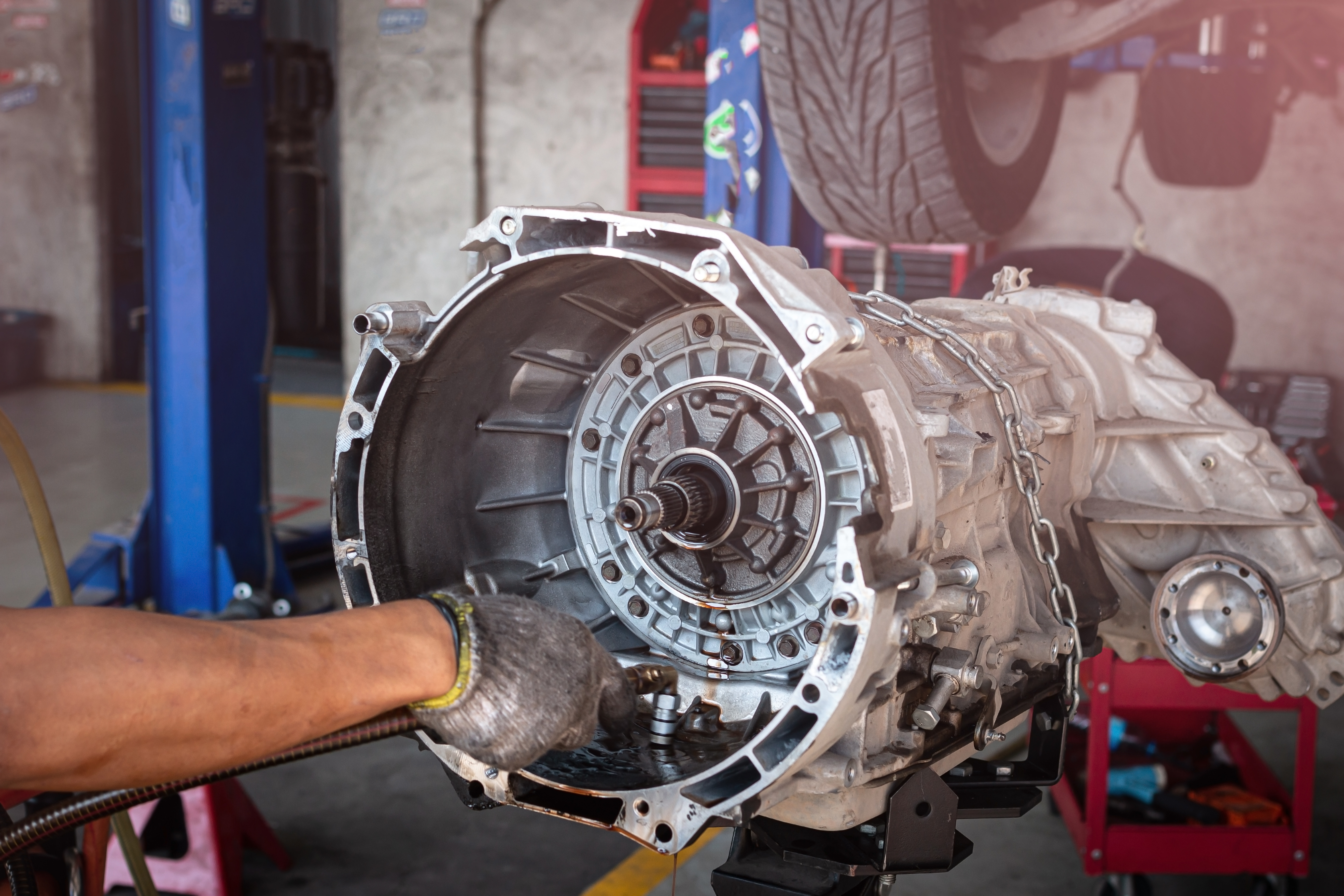 Mechanic removing transmission from vehicle